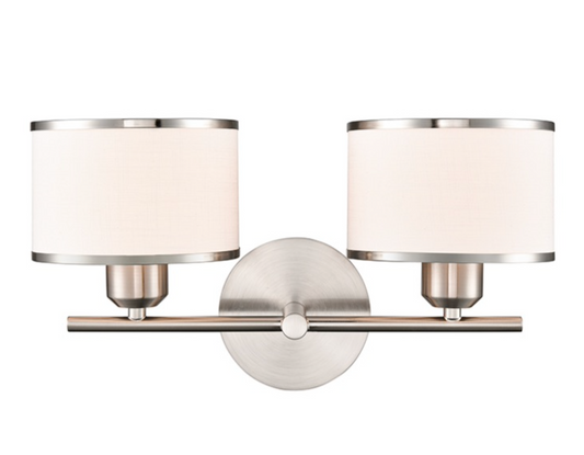 A modern two-light wall sconce with cylindrical off-white fabric shades and brushed silver metal hardware, shown against a plain white background.